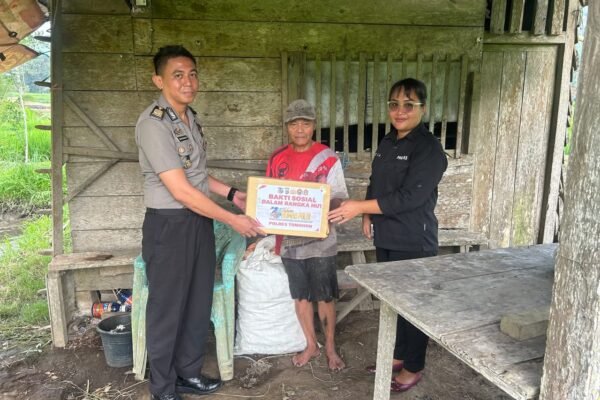 Personel Humas Polres Tomohon menyerahkan paket sembako bakti sosial HUT ke-75 Humas Polri kepada warga